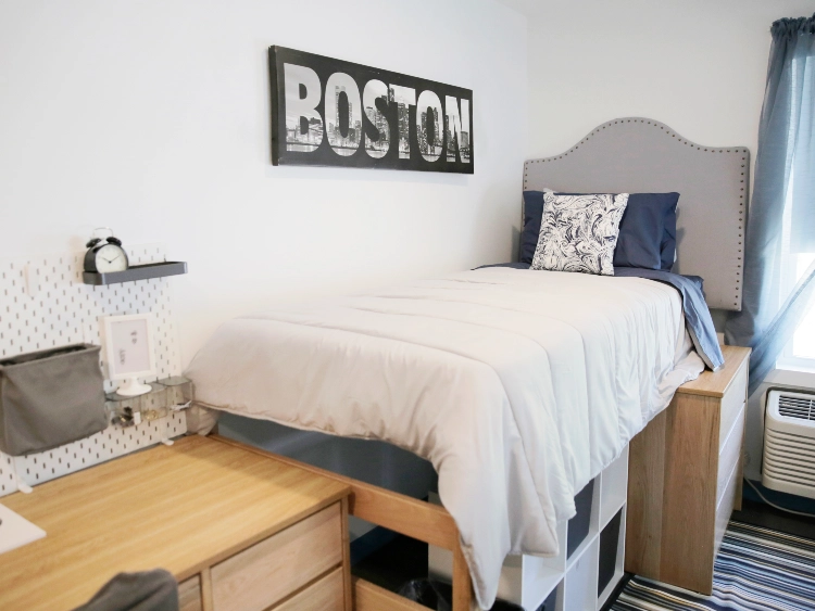 CATS Academy Boston single dorm room with a lofted bed, desk and Boston wall art